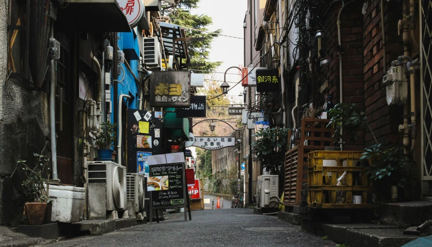 a narrow urban street is crowded with colorful signs