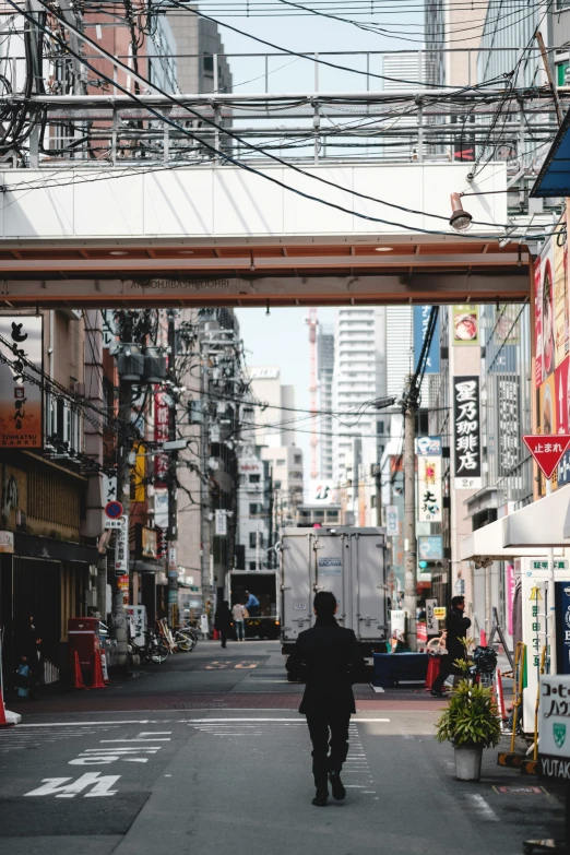 a man walks down an alley in an asian city