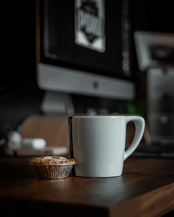 a cup of coffee on a desk with some small cookies