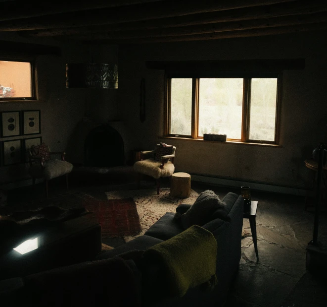 a dark living room with couches and a table