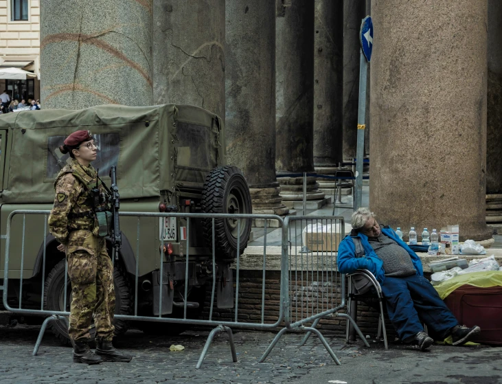 two people standing in front of an army vehicle