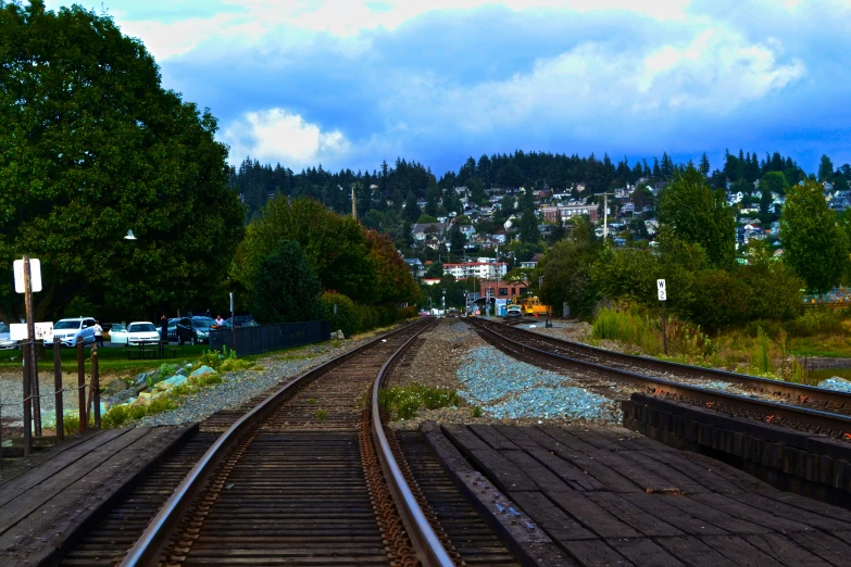 an overview po of train tracks, trees, and a town