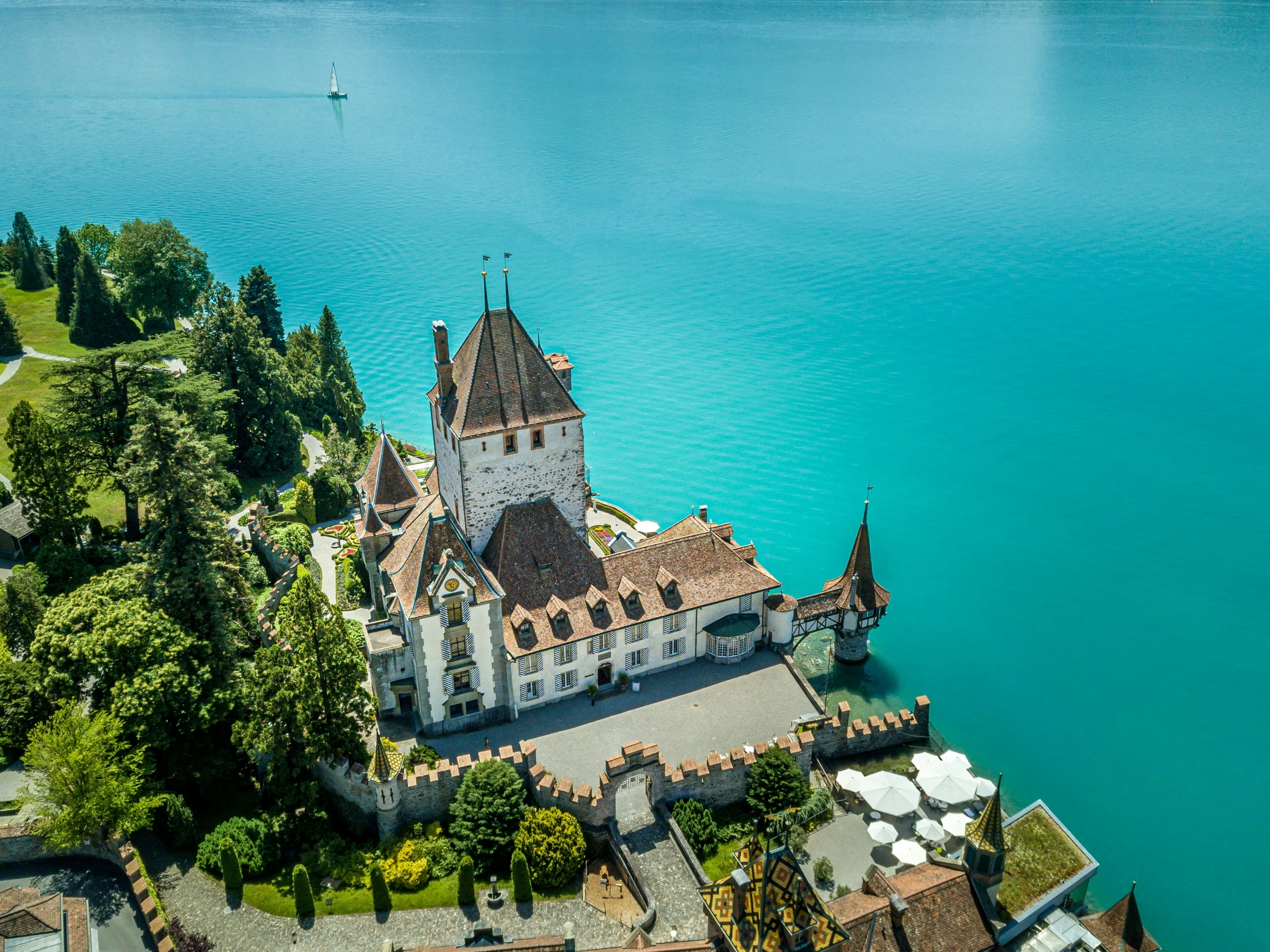 a castle by the water surrounded by trees