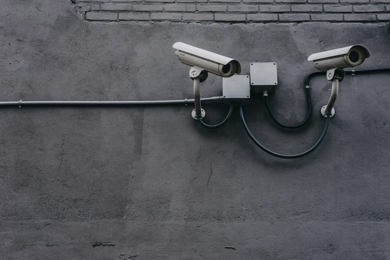two security cameras on the side of a building