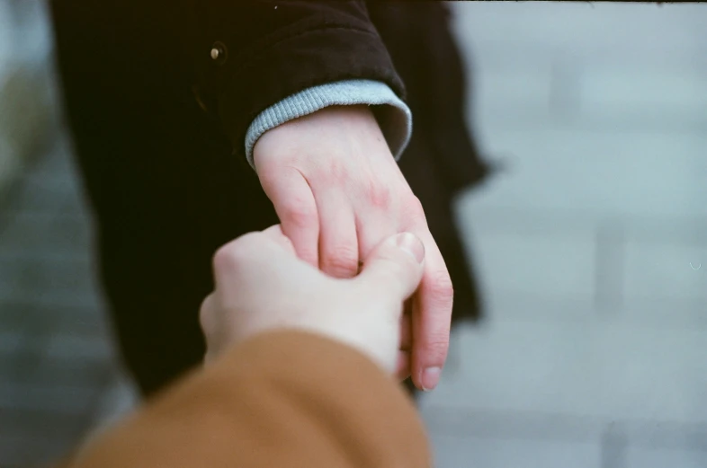two hands holding each other with their fingers