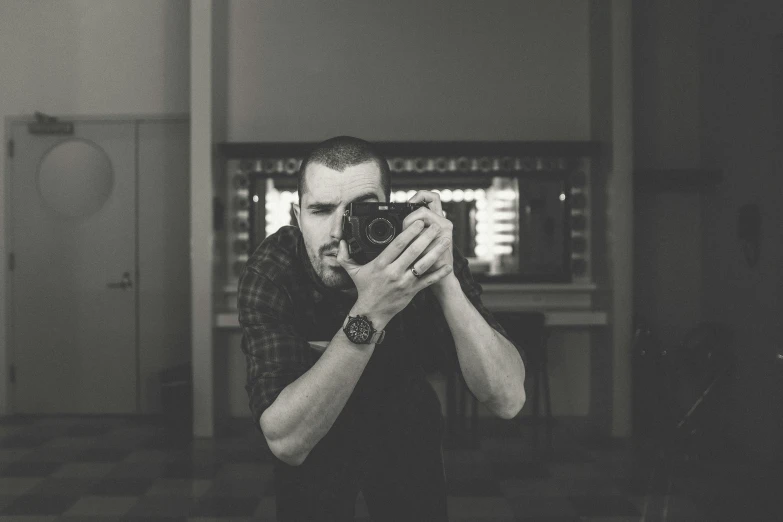 man standing in the doorway taking a selfie with his camera