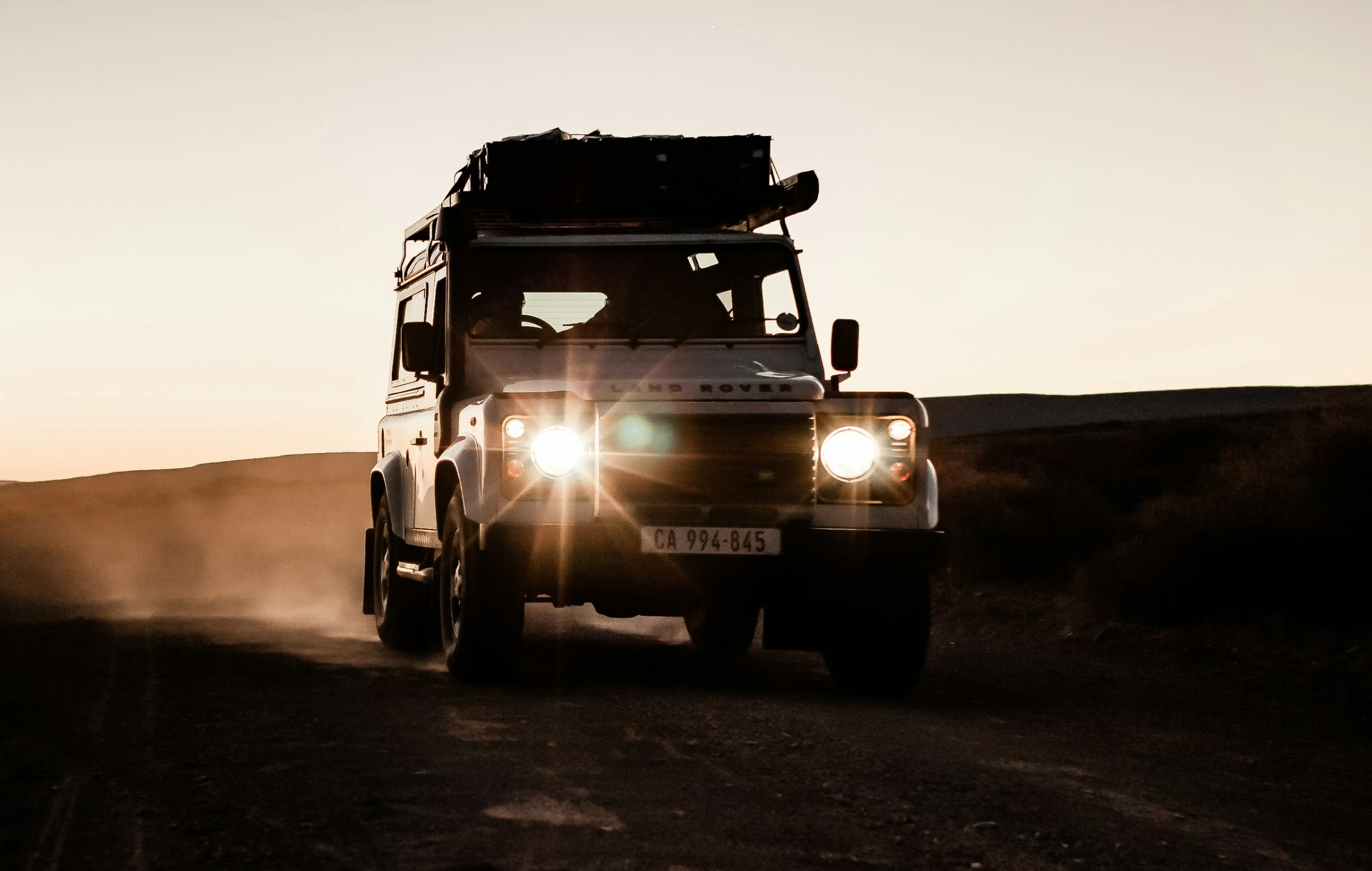 a truck drives along a road with the sun setting