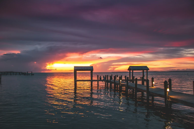 a dock that is next to some water and a sky