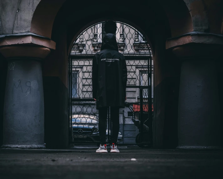 a person is standing near a large archway