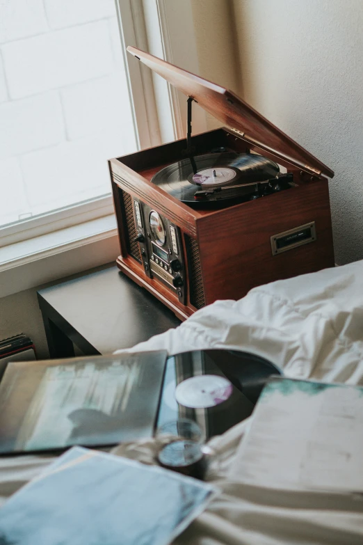 the record player is on the bed by the window