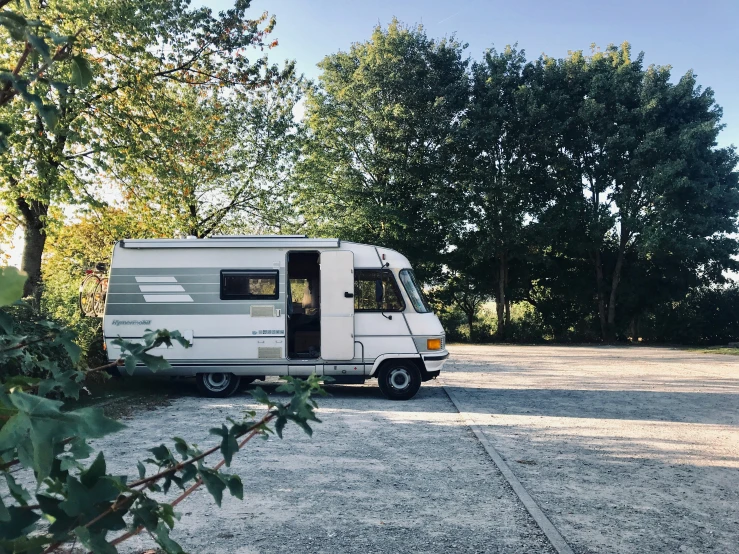 a white rv that is sitting in the shade