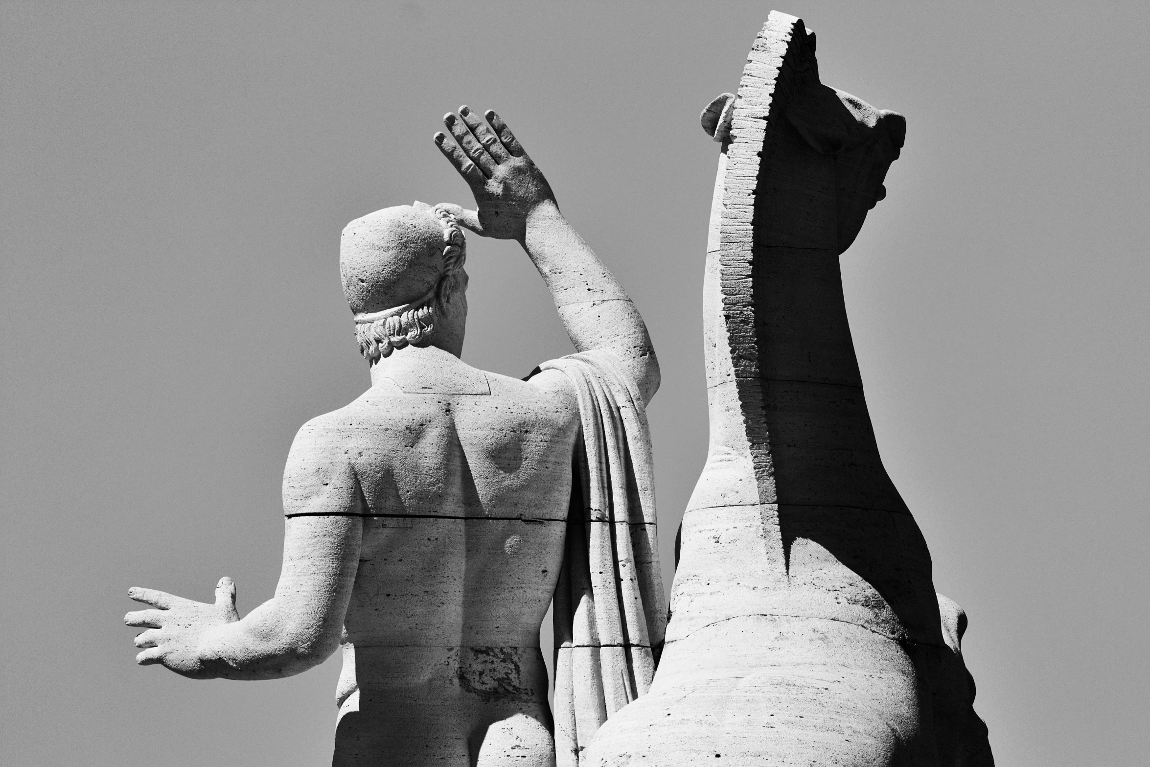 the statue of a man reaching up to a large alligator