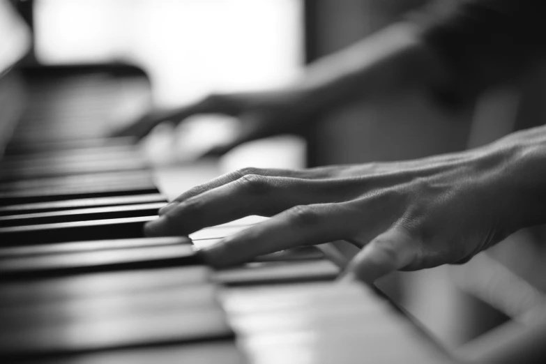 a hand on the keys of a piano