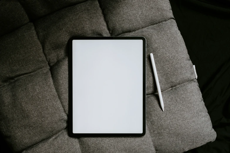 a note pad and pen on a grey pillow