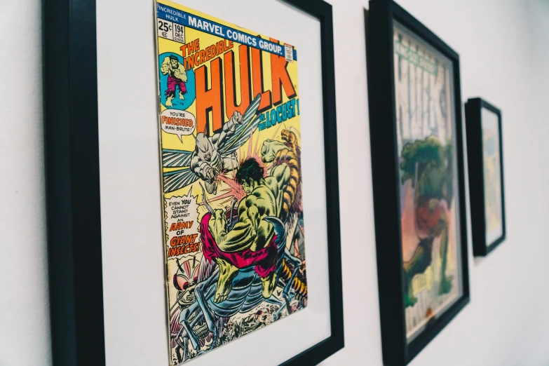 three comic book covers are hung up next to each other