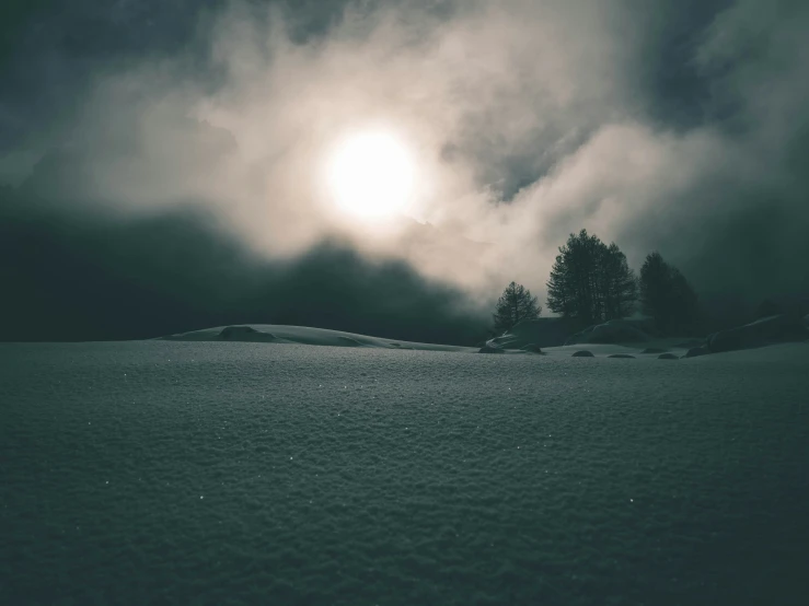 snow covered ground near the sun on a cloudy day