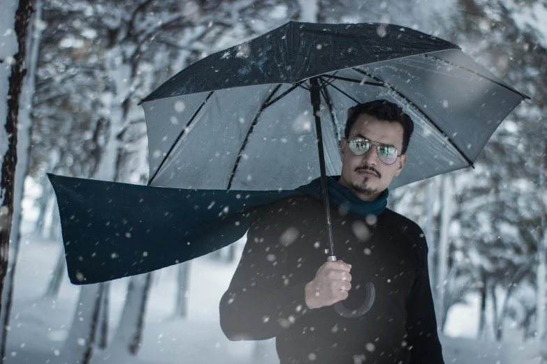 a man in the snow holding an umbrella