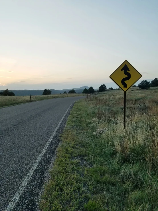 a road sign in the middle of a grassy field