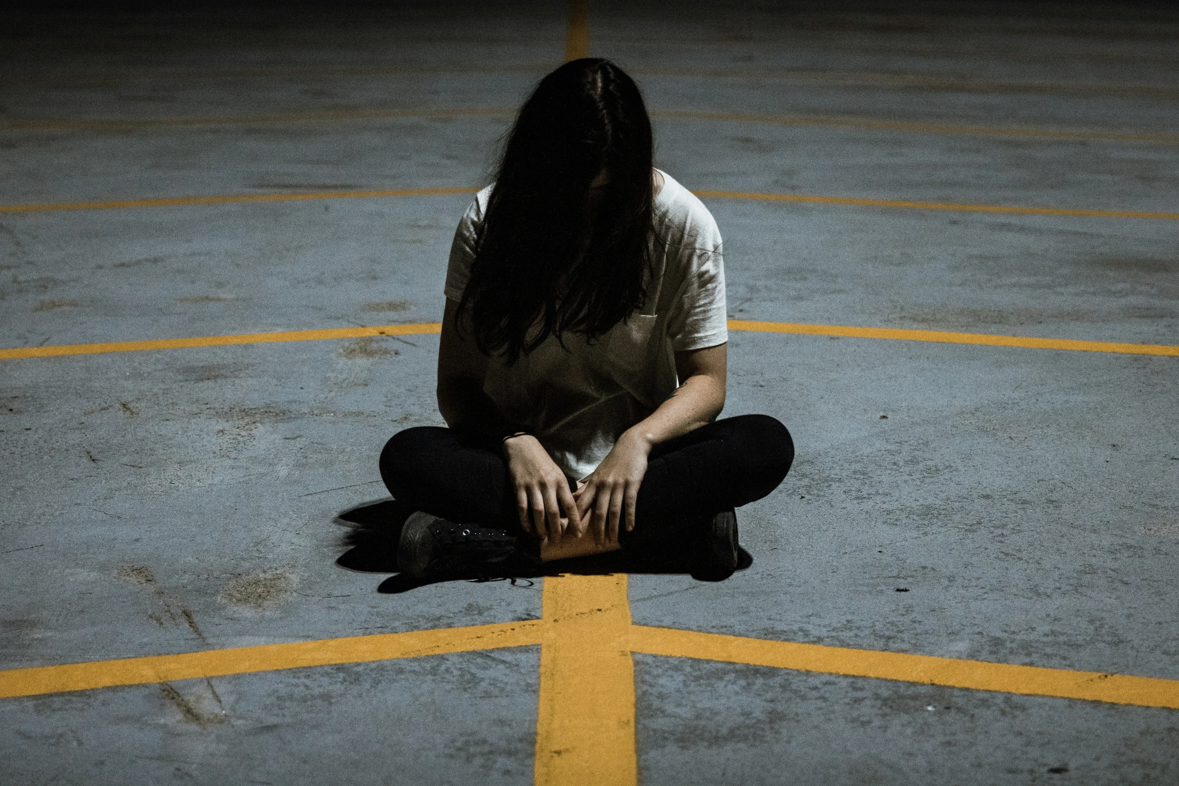 a woman sits in the middle of the pavement and waits for her turn