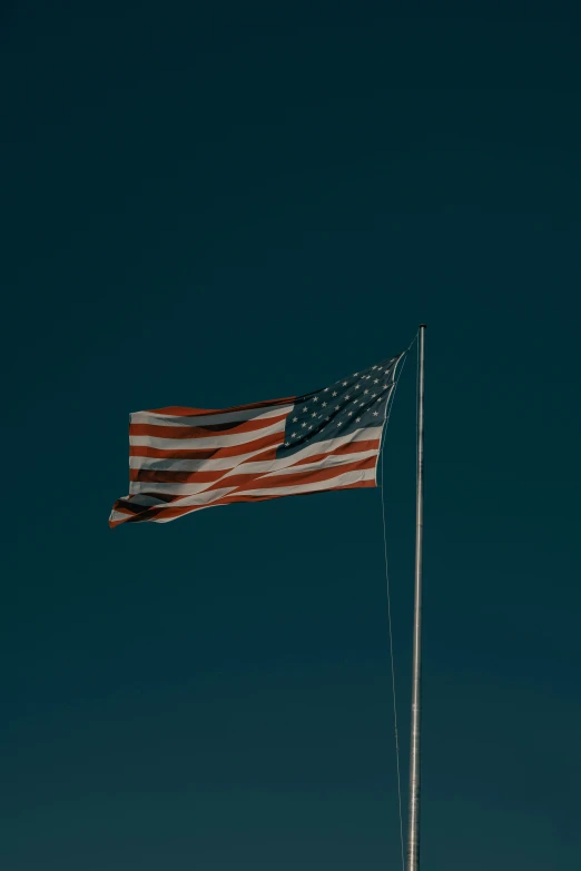 the american flag waving in the sky on a sunny day