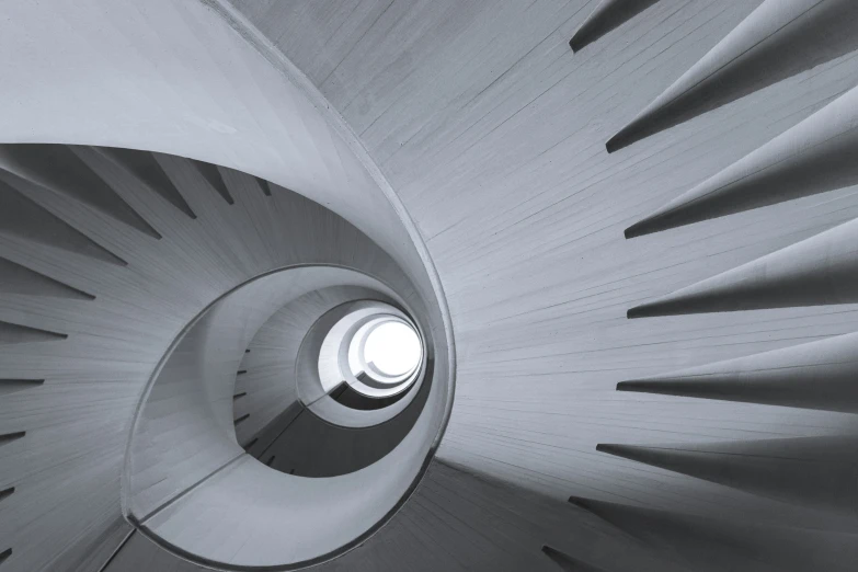 spiral stair with light coming through it in black and white