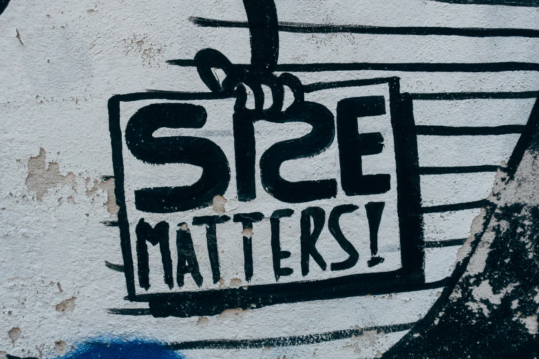 graffiti on a wall that reads size matters