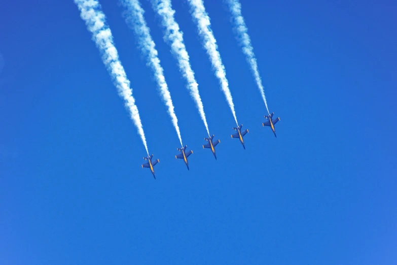 nine planes are flying in the air with their contrails