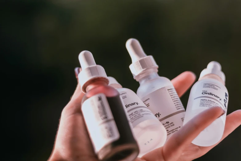 three bottles of medication on a person's hand