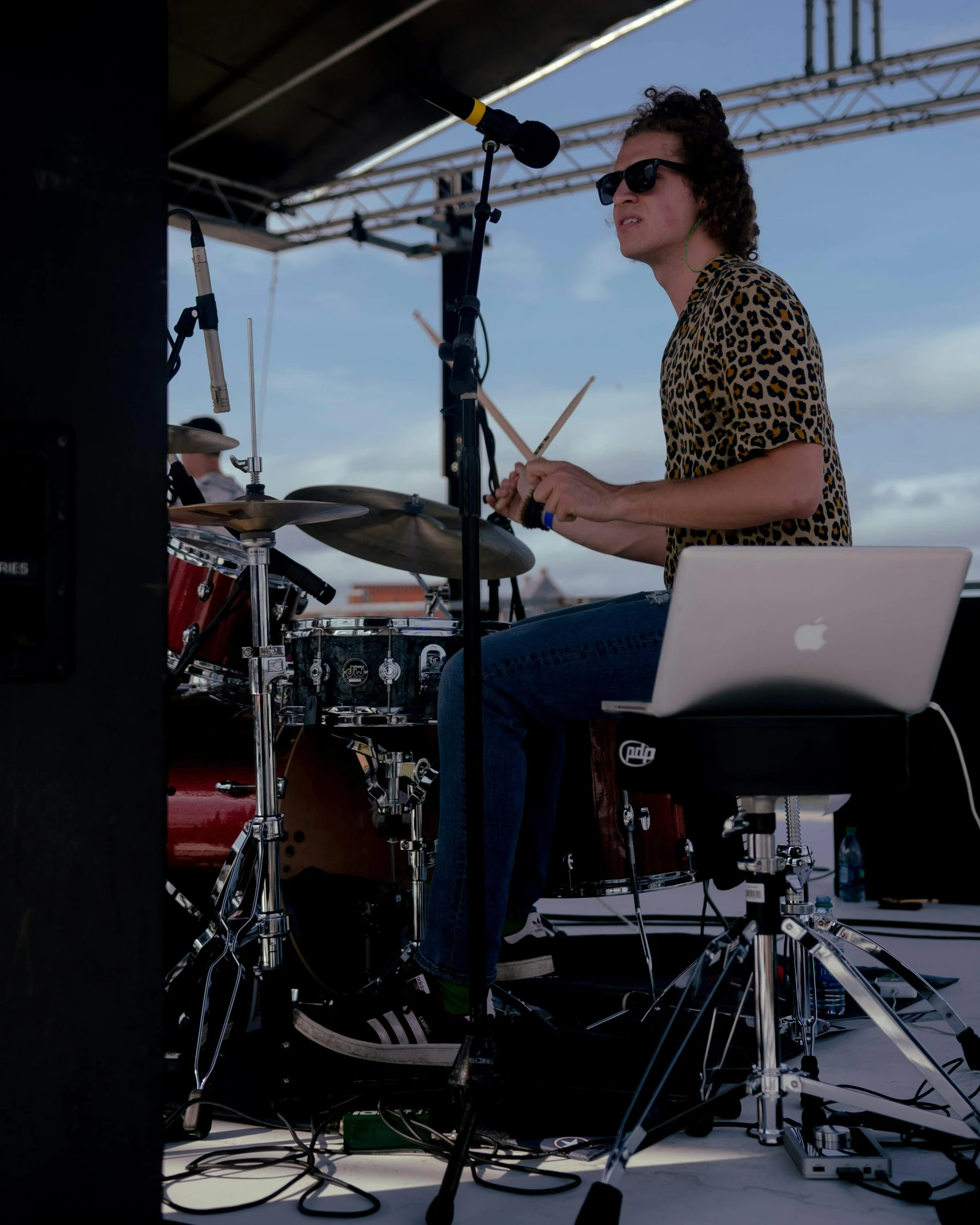 a man sitting at the drums and a computer