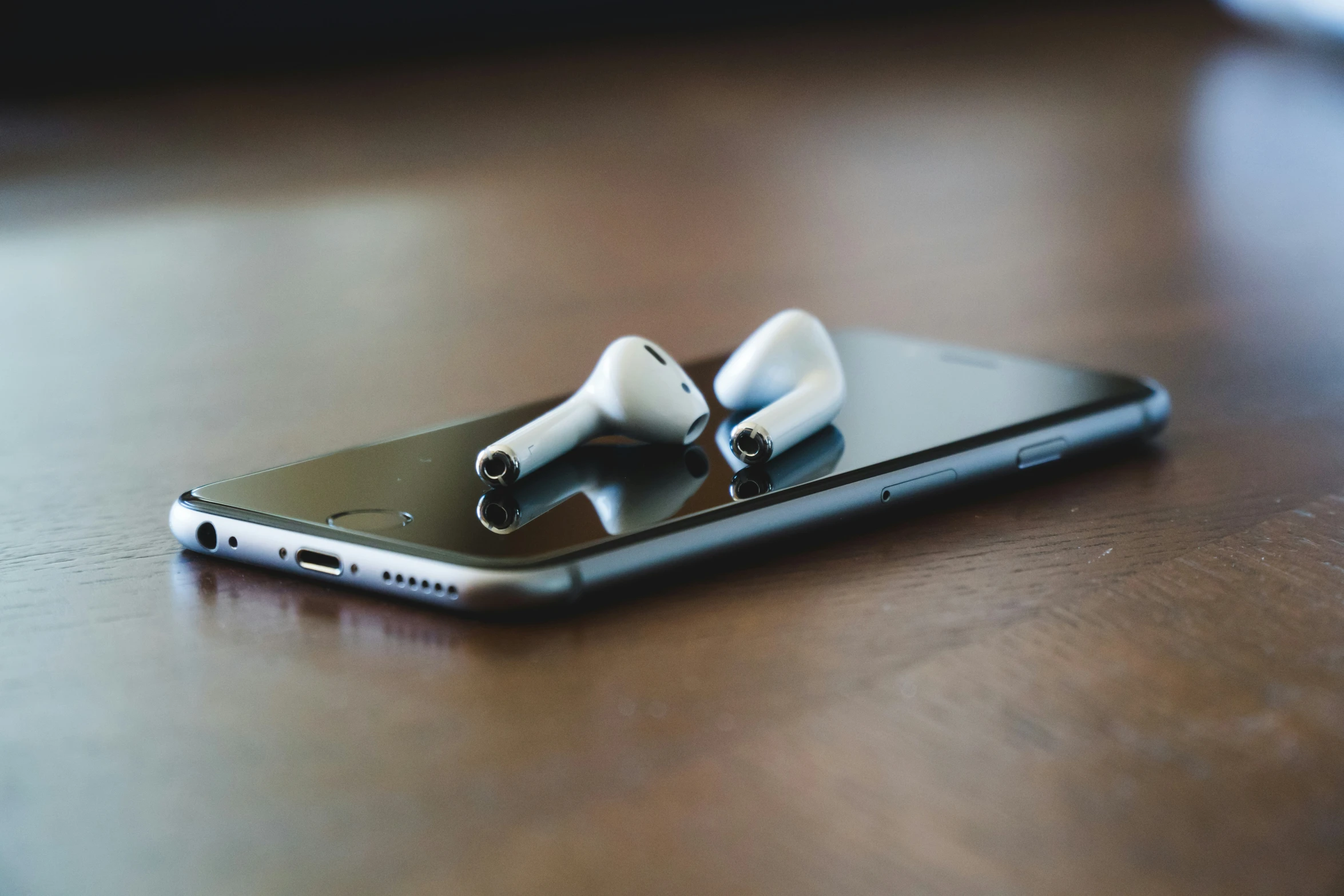 ear buds sitting on top of a phone