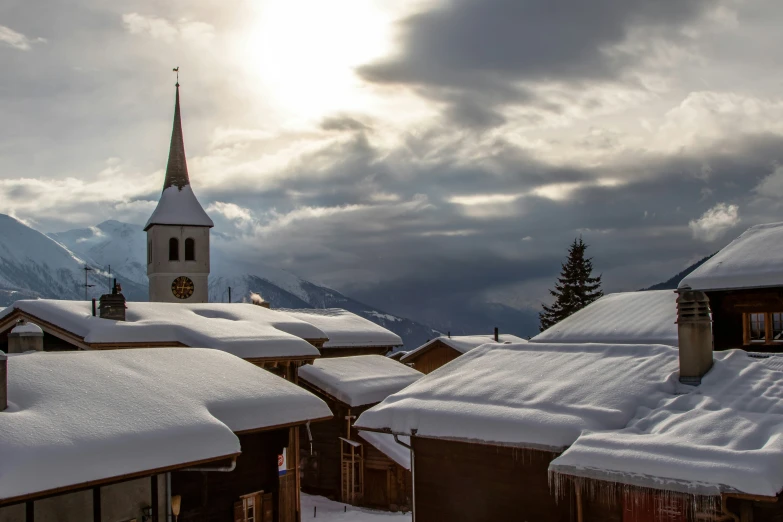 a town with snow covered roofs in front of mountains