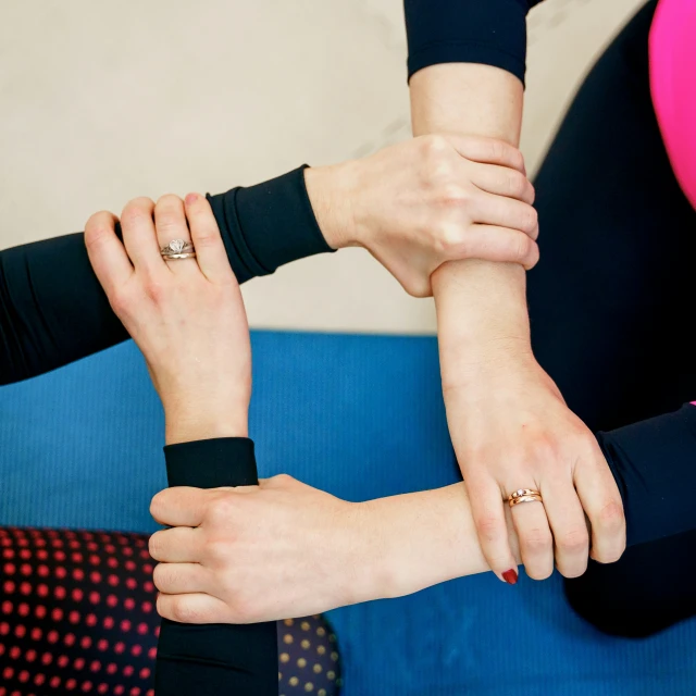 four people holding hands wearing wedding rings