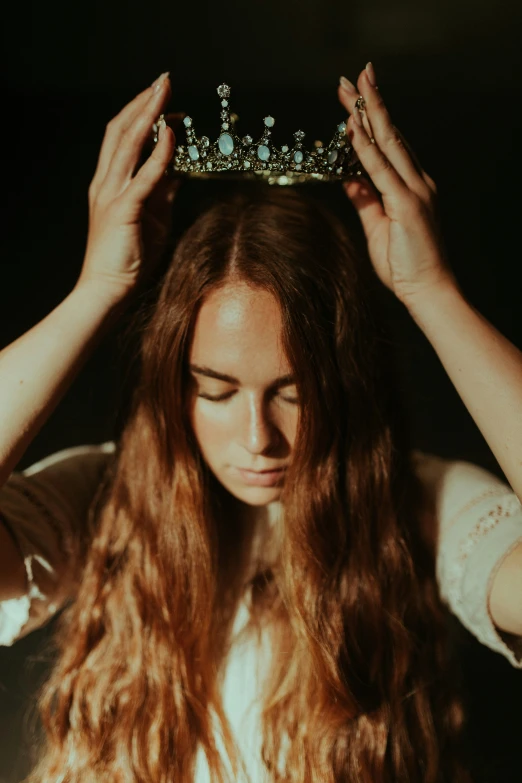 a  holds a crown above her head