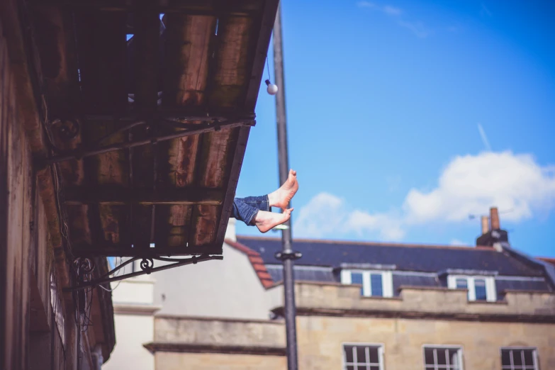 a man jumps in the air on a pole near a building