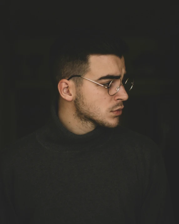 a man wearing glasses is looking off into the distance