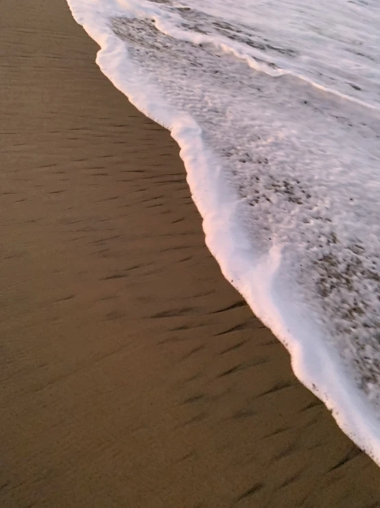 a beach with two surfboards next to the ocean