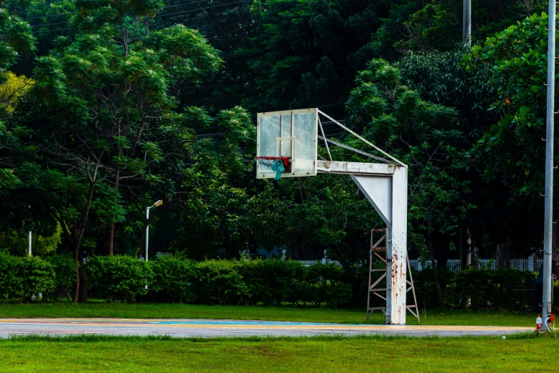 a basketball hoop in a park near a parking lot