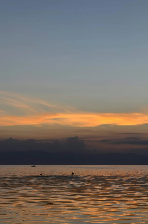 a man on a boat is silhouetted by a colorful sunset