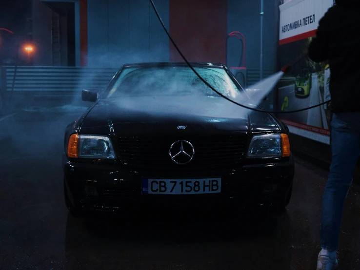 a person is refilling a mercedes benz w122 at night