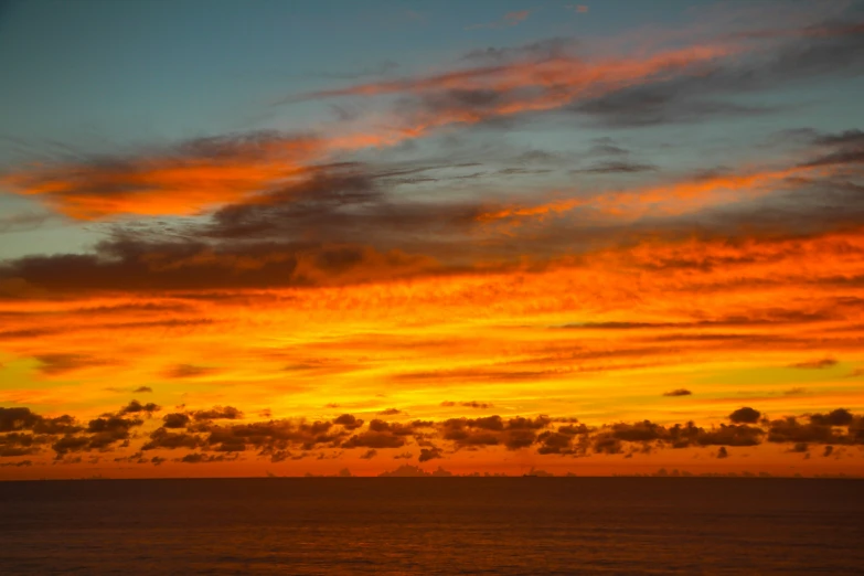 sunset and clouds over the ocean on a clear day