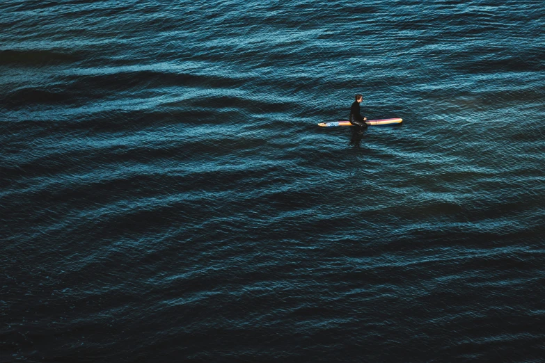 a man in the water on a surfboard with a paddle