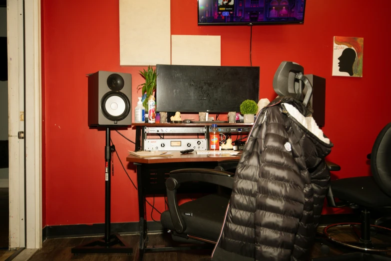 an office with a monitor, chair and speakers