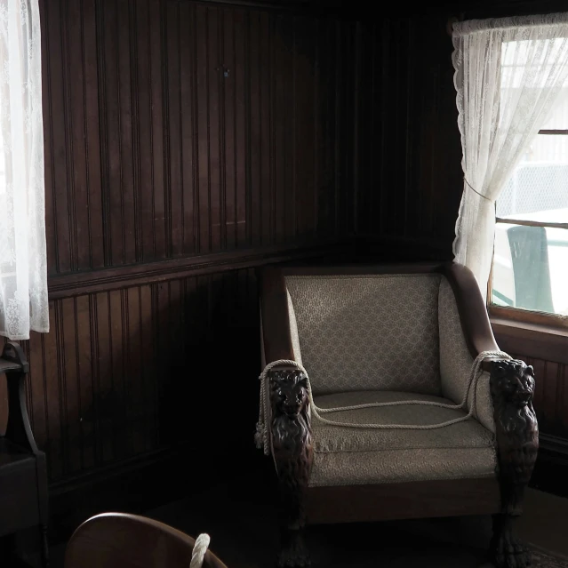 an empty armchair in front of a window with a cat face on it