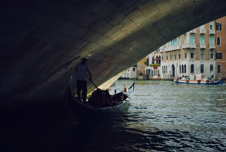 a couple of boats are under a bridge