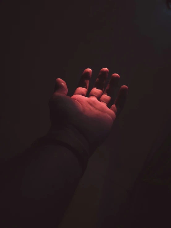 the hand is glowing against the dark backdrop