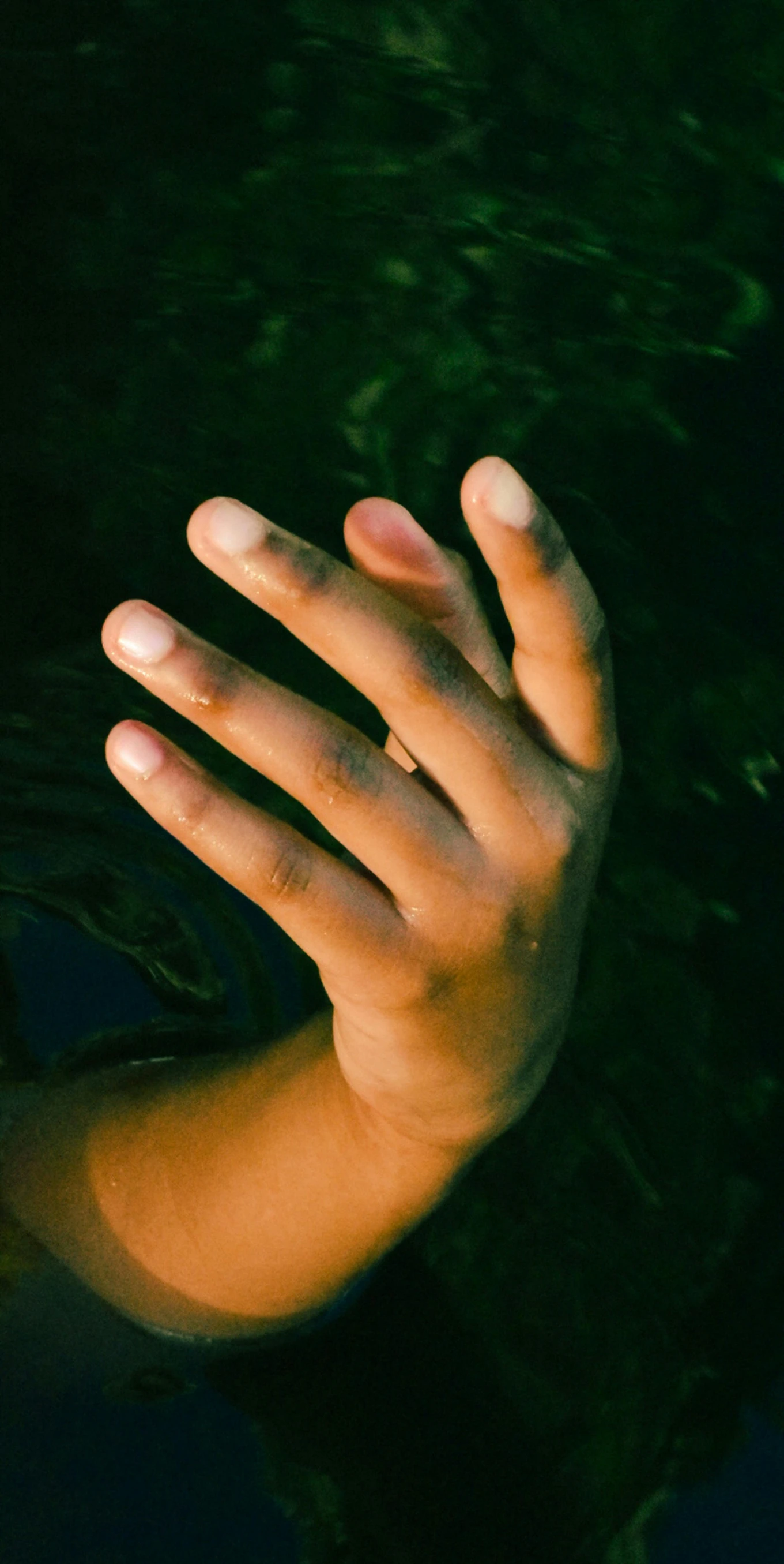 a persons hand outstretched and touching soing on a table