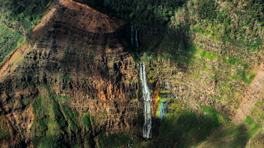 a waterfall in the side of a large hill