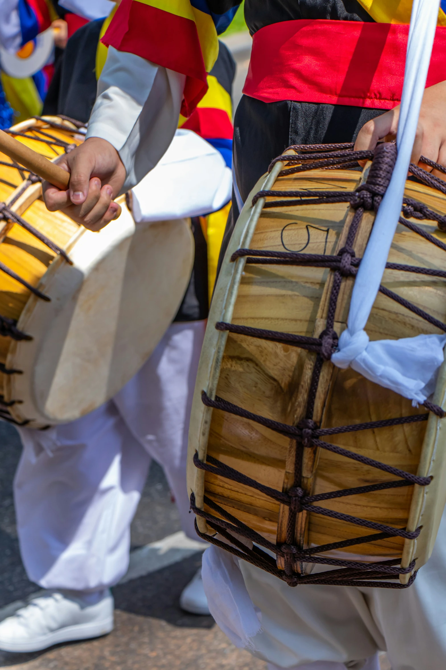 a couple of people playing drums together on a street