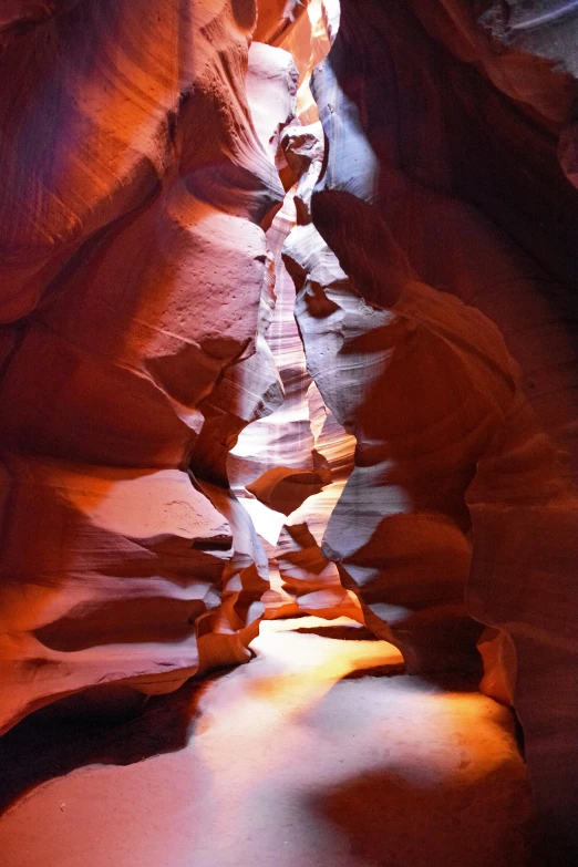 a narrow narrow stream with large rocks and sand