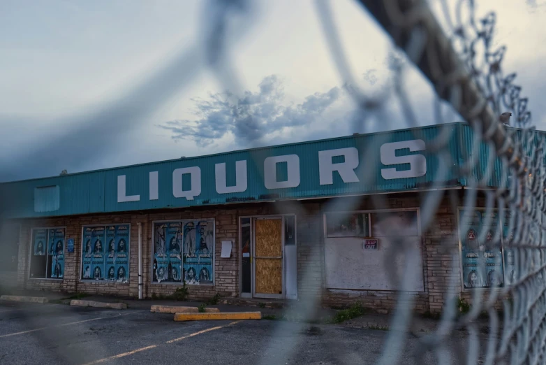 there is a liquor store that has faded glass windows